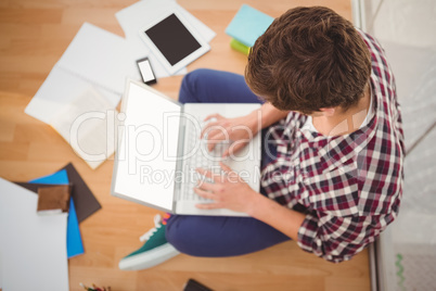 Creative businessman working on laptop in office