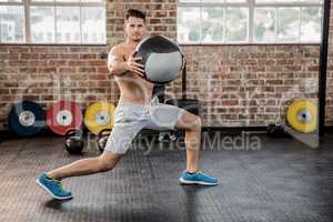 Portrait of muscular man exercising with medicine ball
