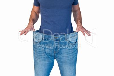 Midsection of man stretching denim jeans