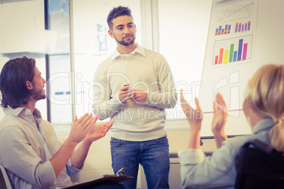Business people clapping for confident male colleague