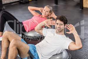 Fit couple doing abdominal crunches