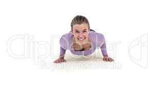 Portrait of happy young woman doing push ups