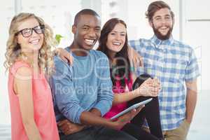 Portrait of cheerful business people with man holding tablet