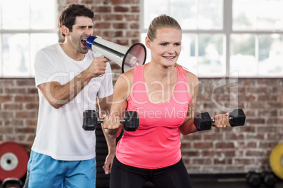 Personal trainor motivating his client with megaphone