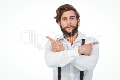 Confident hipster pointing sideways with arms crossed