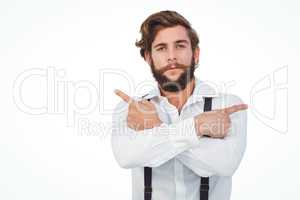 Confident hipster pointing sideways with arms crossed