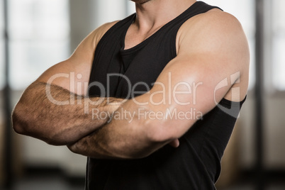 Midsection of man with arms crossed