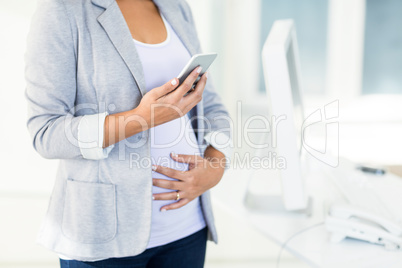 Pregnant businesswoman using phone