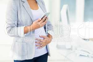 Pregnant businesswoman using phone