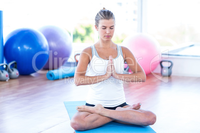 Woman meditating in fitness studio