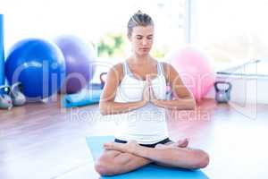 Woman meditating in fitness studio