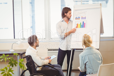 Businessman explaining multi colored graph to colleagues