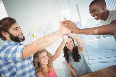 Cheerful business people giving high five at desk