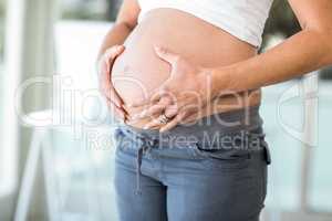 Midsection of woman touching abdomen