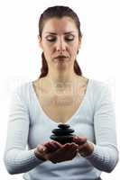 Woman with eyes closed while holding pebbles