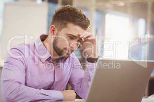 Worried businessman looking at laptop