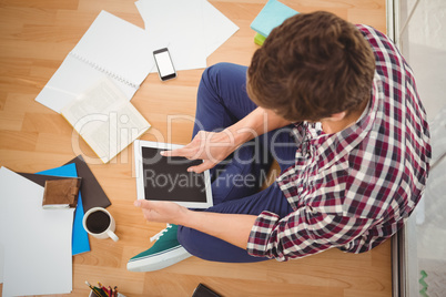 Hipster working on digital tablet in office