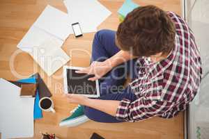 Hipster working on digital tablet in office