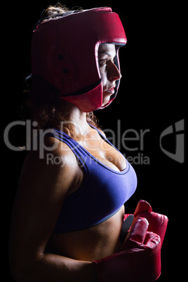 Side view of female boxer with headgear and gloves