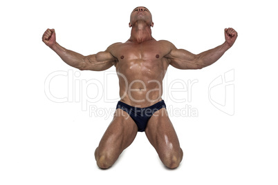 Muscular man kneeling down with arms outstretched