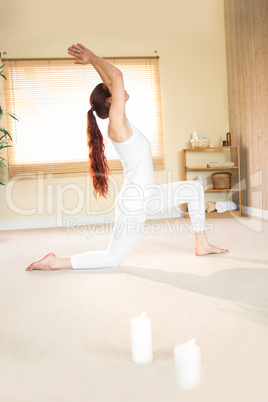 Full length of woman meditating with arms raised