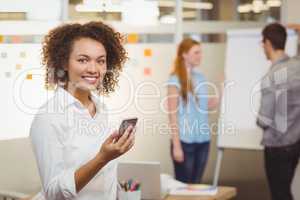 Smiling businesswoman using mobile phone