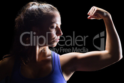 Confident female athlete flexing muscles