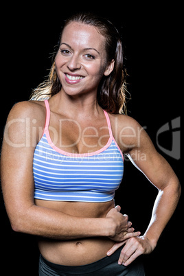 Portrait of smiling athlete with hands on hip