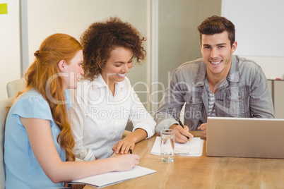 Smiling businessman with colleagues in meeting Smiling businessman with colleagues in meeting
