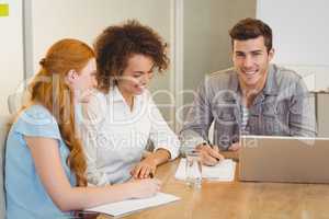 Smiling businessman with colleagues in meeting