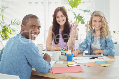 Portrait of cheerful business people while working at desk