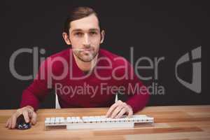 Portrait of confident creative businessman sitting at desk