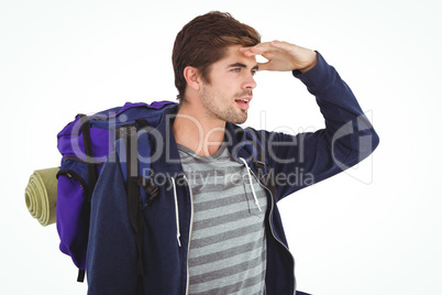 Man with backpack shielding eyes