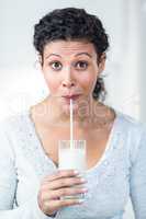 Beautiful pregnant woman drinking a glass of milk
