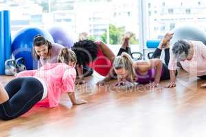Women exercising on floor with trainer