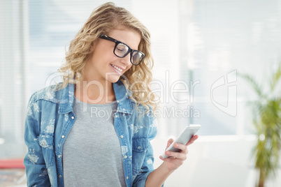 Smiling woman wearing eyeglasses while using smartphone