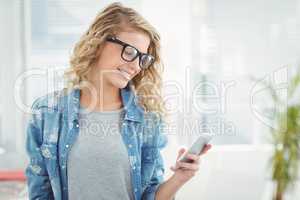 Smiling woman wearing eyeglasses while using smartphone