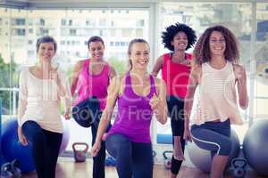 Smiling women exercising with clasped hands
