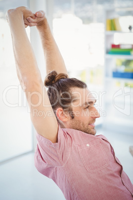 Businessman stretching in office