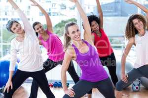 Portrait of cheerful women exercising with arms raised
