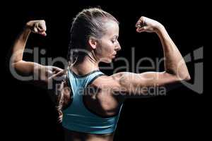 Athlete woman flexing muscles