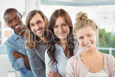 Portrait of smiling business team with arms crossed while standi