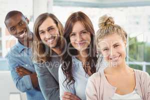 Portrait of smiling business team with arms crossed while standi