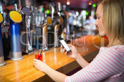 Young woman with mobile phone holding glass