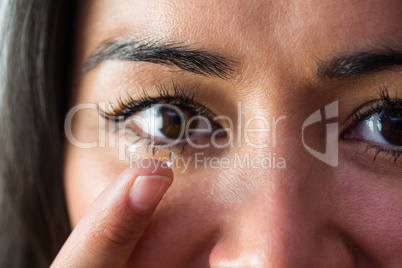 Smiling woman with a contact lens
