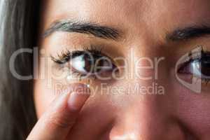 Smiling woman with a contact lens