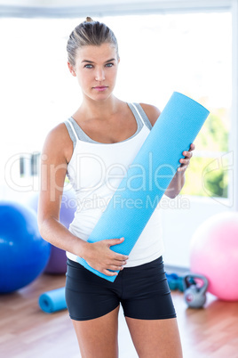 Beautiful woman holding yoga mat