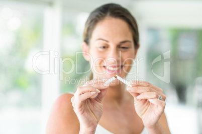 Happy woman breaking cigarette