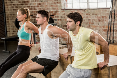 Cropped image of people holding plyo box and exercising