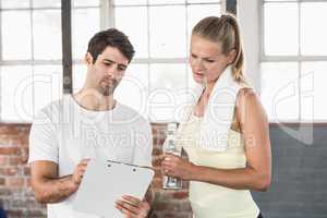 Muscular woman watching her results on clipboard